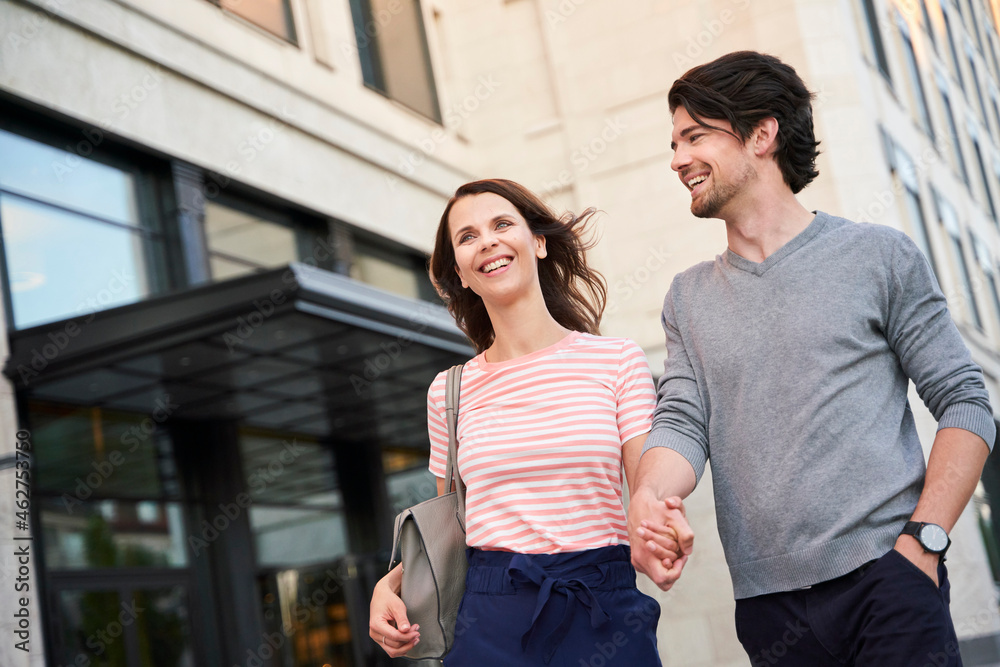 Happy couple walking hand in hand in the city Happy couple walking hand in hand in the city