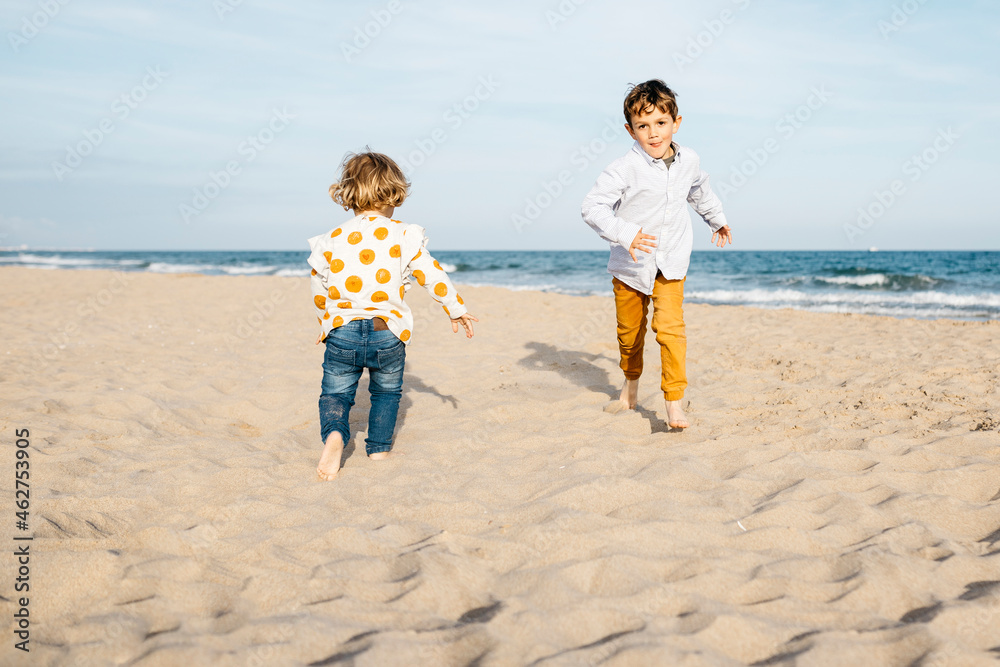 Boy and his little sister playing on the beach Boy and his little sister playing on the beach
