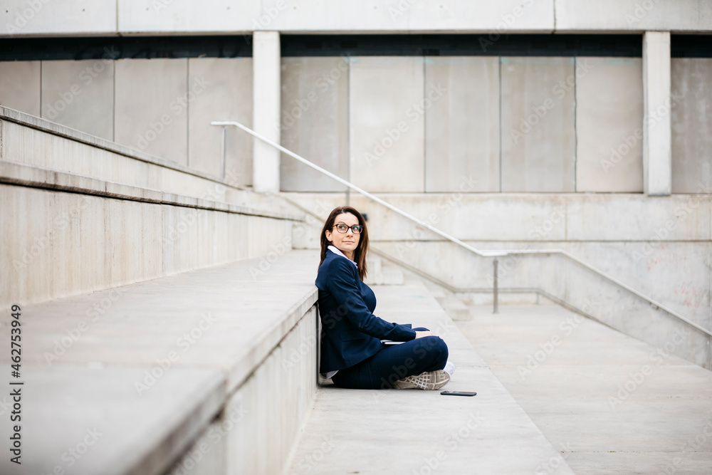 Businesswoman sitting outdoors on stairs with laptop Businesswoman sitting outdoors on stairs with laptop