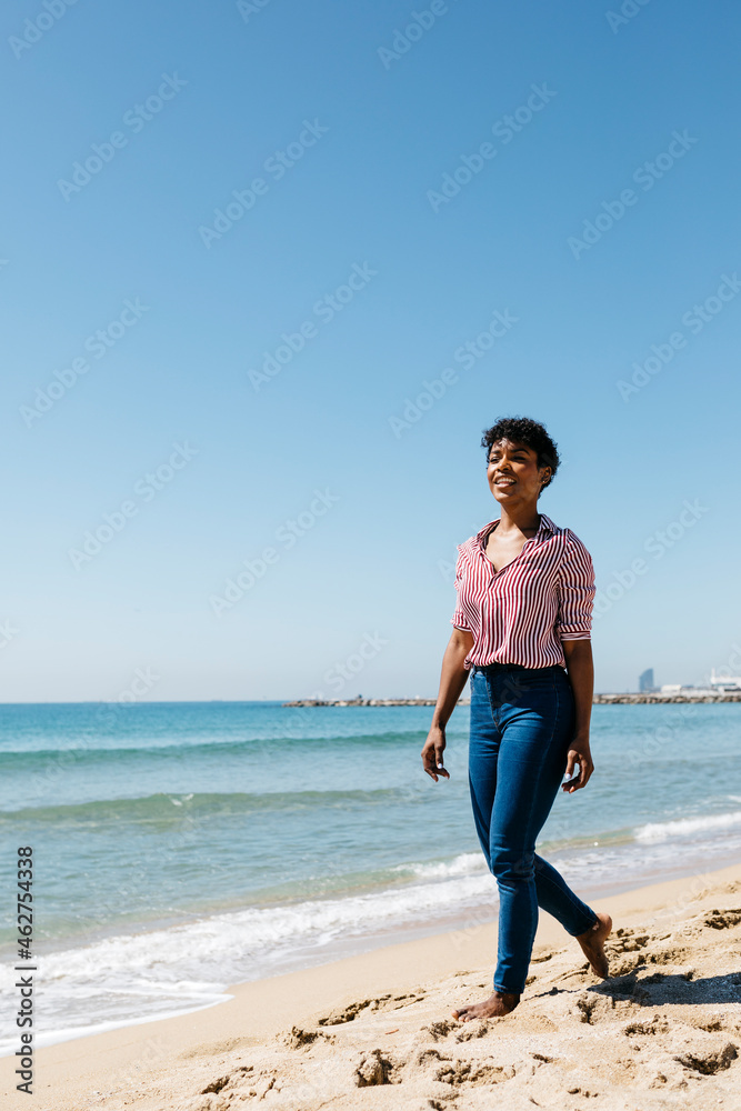 Woman walking on the beach, enjoying the sun after work Woman walking on the beach, enjoying the sun after work