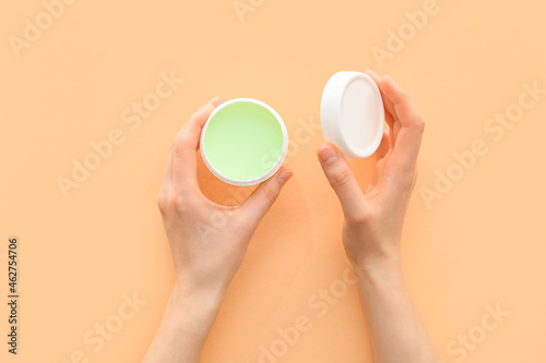 Woman with hand cream on light background