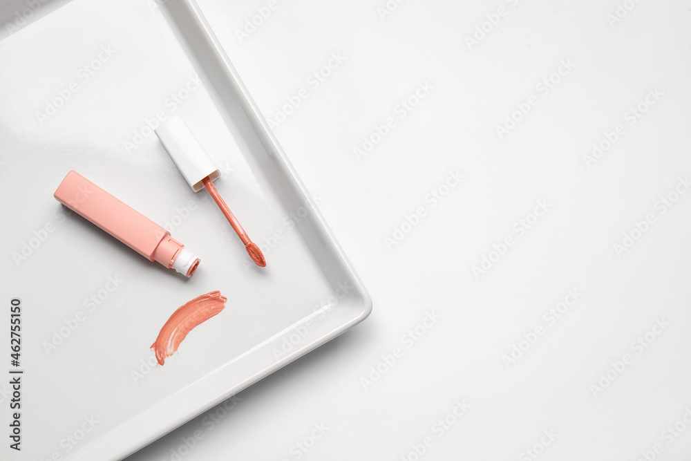 Plate with lipstick on white background