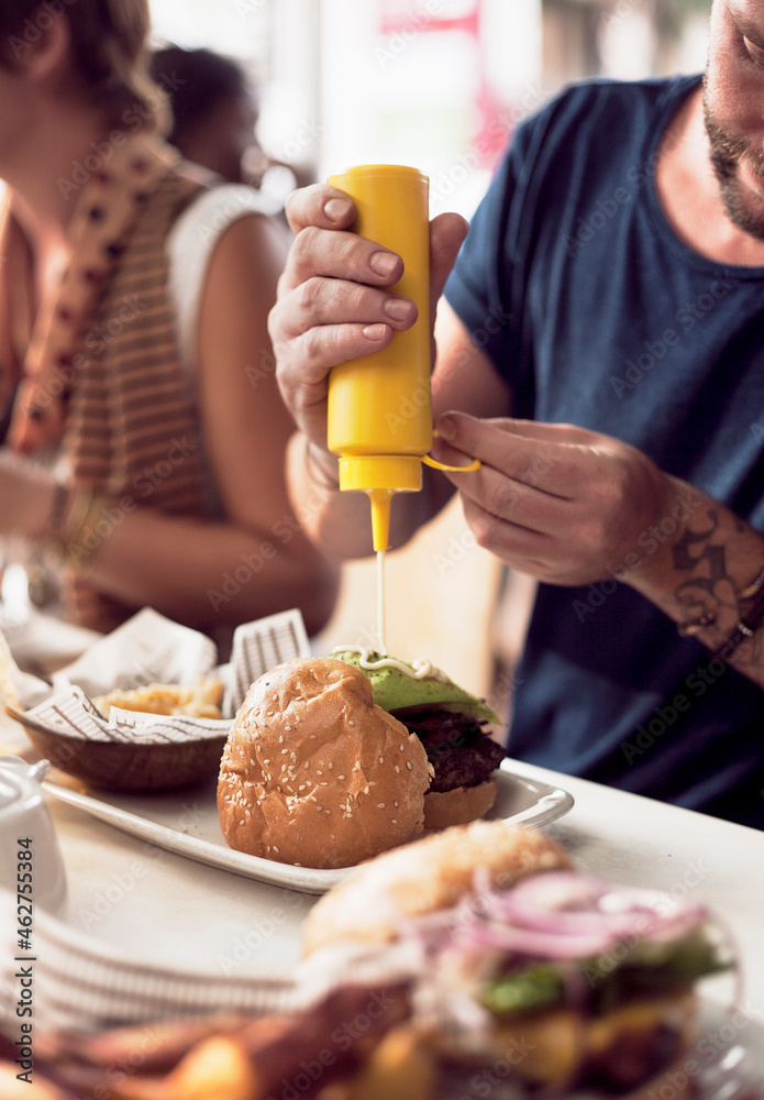 Man eating burger in restaurant Man eating burger in restaurant