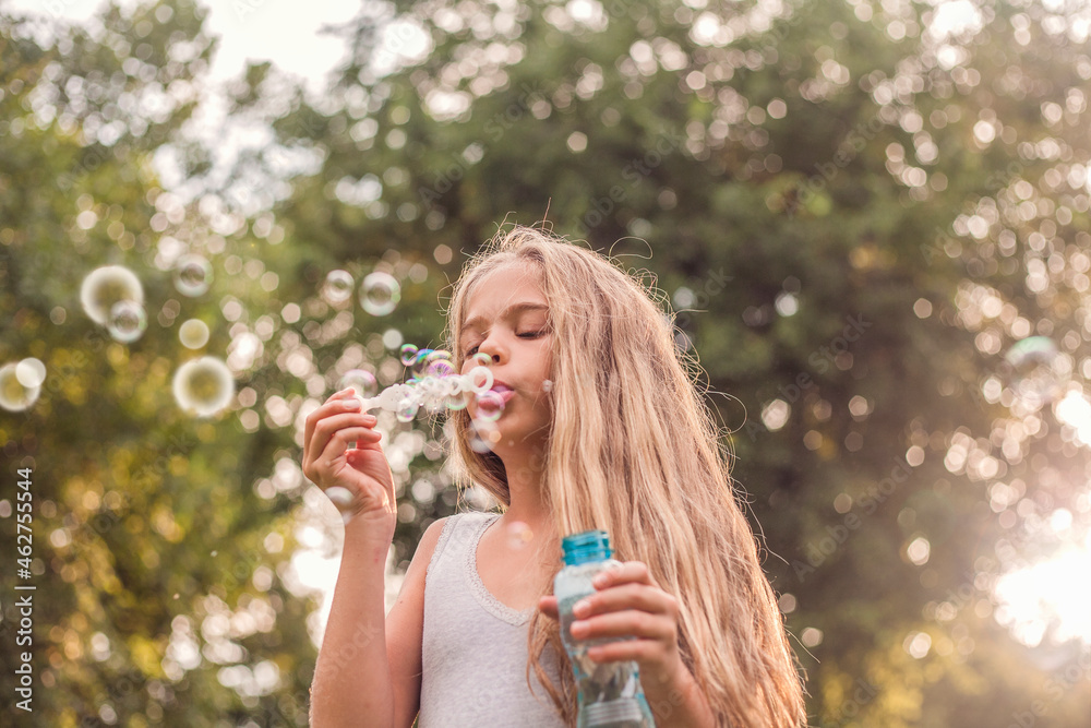 Cute girl blowing bubbles in park Cute girl blowing bubbles in park