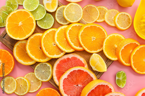 Slices of citrus fruits on color background, closeup