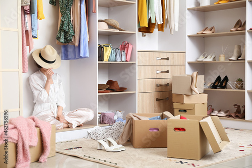 Young woman arranging clothes at wardrobe