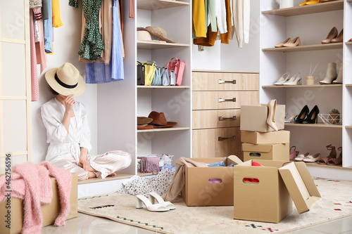 Young woman arranging clothes at wardrobe photo