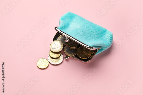 Blue wallet with coins on pink background