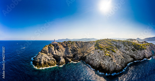 Spain, Mallorca, Cala Ratjada, Helicopter view of sun shining over coastal cliffs and Far de Capdepera lighthouse in summer photo