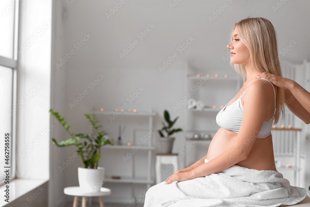 Young pregnant woman having massage in spa salon Young pregnant woman having massage in spa salon