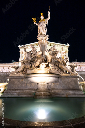 Austria, Vienna, Pallas Athena fountain in front of Parliament building illuminated at night photo