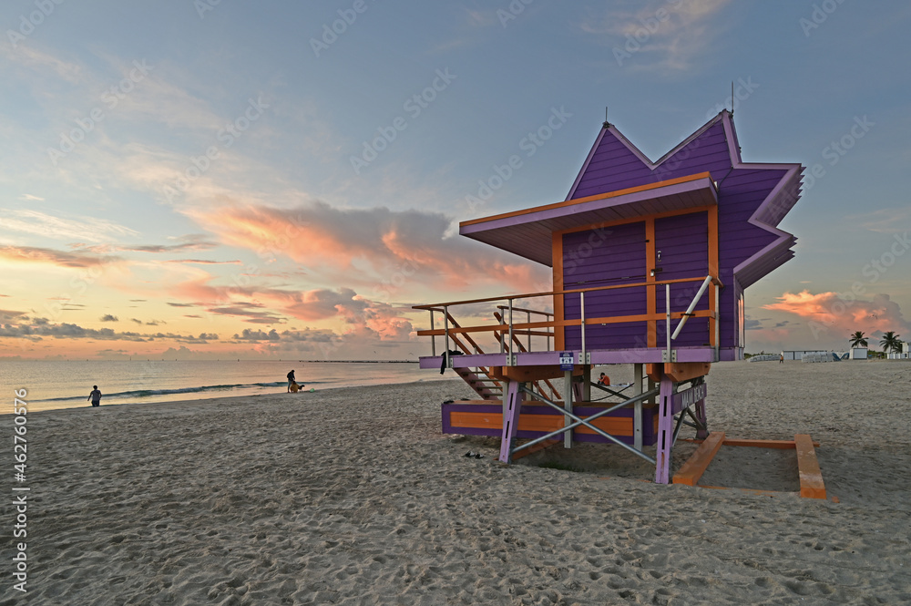 Colorful lifeguard station on Miami Beach, Florida under late summer cloudscape in early morning light.