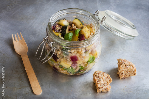 Jar of gluten free vegan salad with buckwheat, zucchini and paprika photo