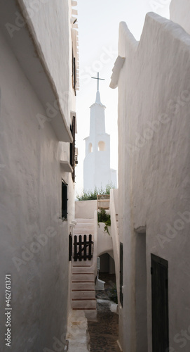 Spain, Menorca, Binibeca, Whitewashed houses and narrow alley photo