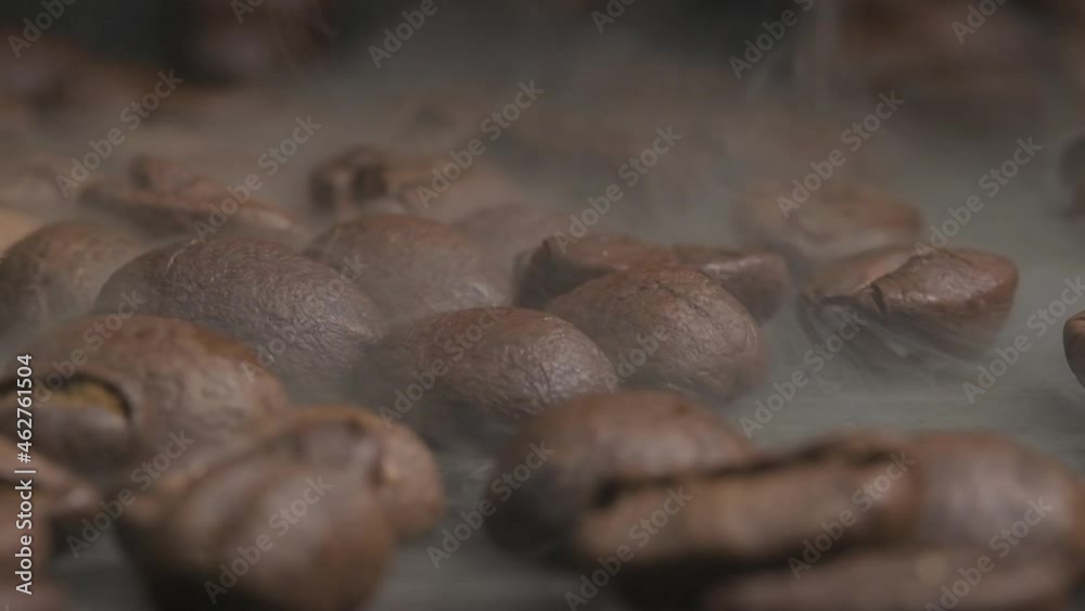 Close up macro shot of roasting coffee beans in a hot oven, thick smoke coming from the beans as they crack and brown to give the barista the perfect desired flavour Close up macro shot of roasting coffee beans in a hot oven, thick smoke coming from the beans as they crack and brown to give the barista the perfect desired flavour