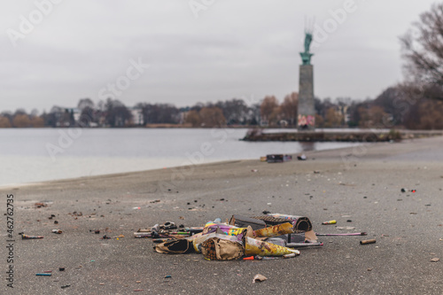 Germany, Hamburg, Garbage lying on sandy shore of Outer Alster Lake photo