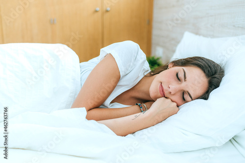 Young woman sleeping in bed at home photo