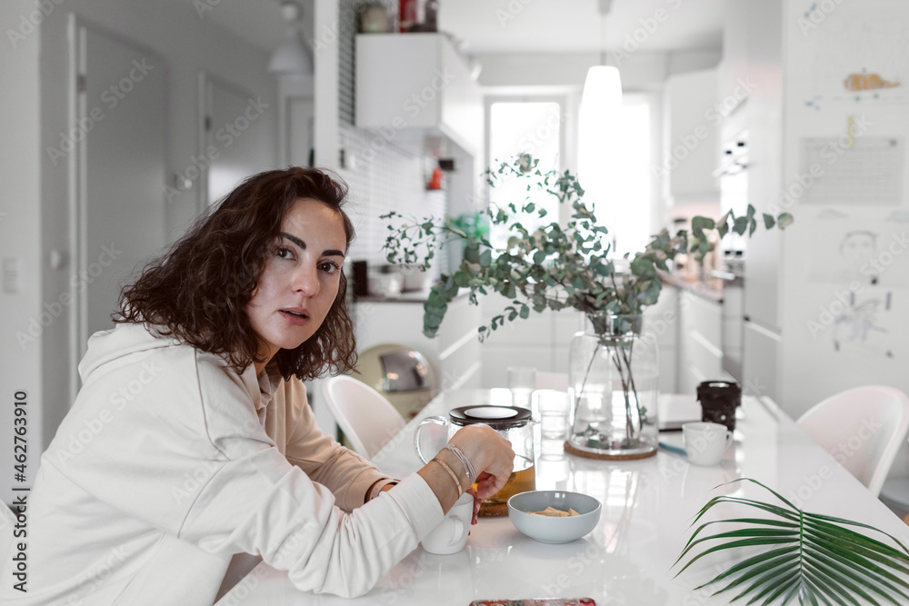 Portrait of woman sitting at kitchen table drinking tea Portrait of woman sitting at kitchen table drinking tea