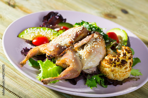 Quail Tabaka (grilled) with sesame served with salad of avocado and fresh greens