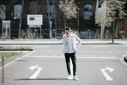 Businessman standing on road with left and right arrows photo