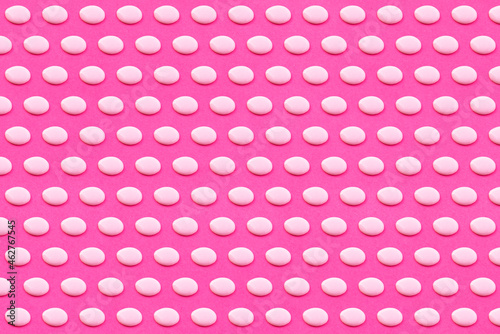 Pattern of white liquid drops against vibrant pink background photo