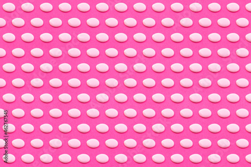 Pattern of white liquid drops against vibrant pink background