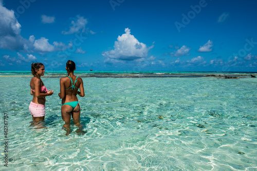 Carribean, Colombia, San Andres, El Acuario, two women standing in shallow turquoise water photo