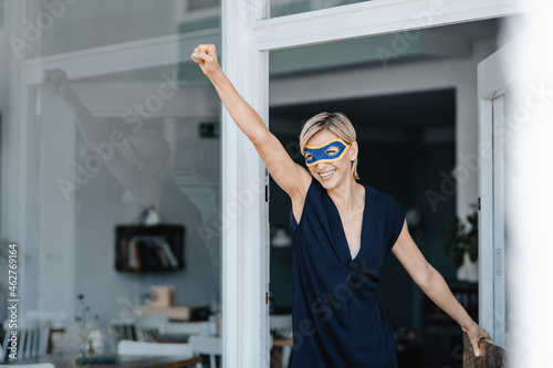 Businesswoman wearing super hero masks, pretending to fly photo