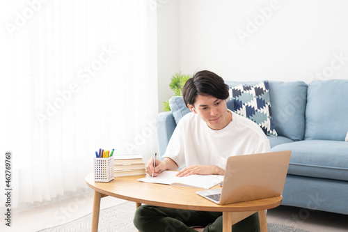 パソコンを見て勉強する若い男性・オンライン授業 photo