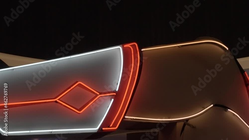 This panning video features a large and kitschy neon cowgirl sign. photo