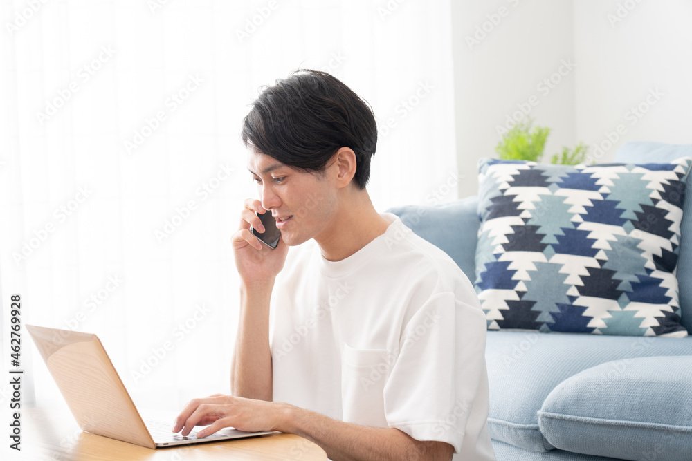 家でパソコンを使い仕事をする若い男性(ビジネスイメージ) 家でパソコンを使い仕事をする若い男性(ビジネスイメージ)