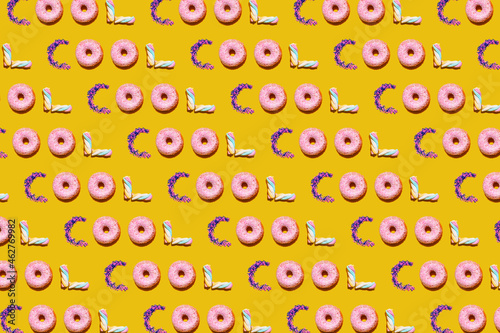 Pattern of doughnuts, marshmallows and sugar sprinkles arranged into single repeated word photo