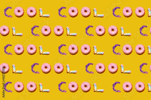 Pattern of doughnuts, marshmallows and sugar sprinkles arranged into single repeated word