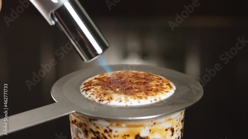 Creme Brulee Milk Tea Drink - Blow Torch Burning Brown Sugar On White Cream With Brulee Ring Protecting Rim of Cup. - close up photo