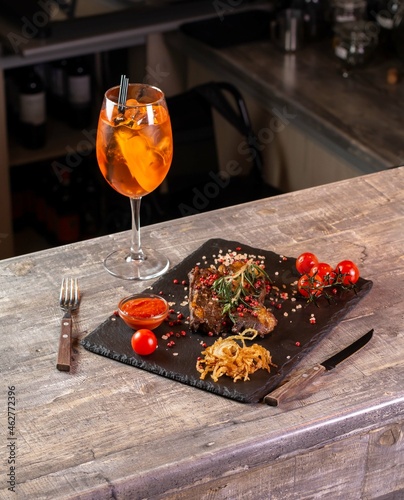 Wineglass and steak with vegetables in restaurant