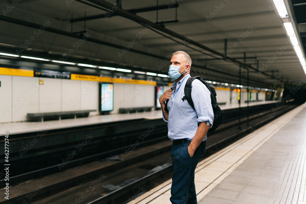 Businessman wearing face mask while standing at subway platform Businessman wearing face mask while standing at subway platform