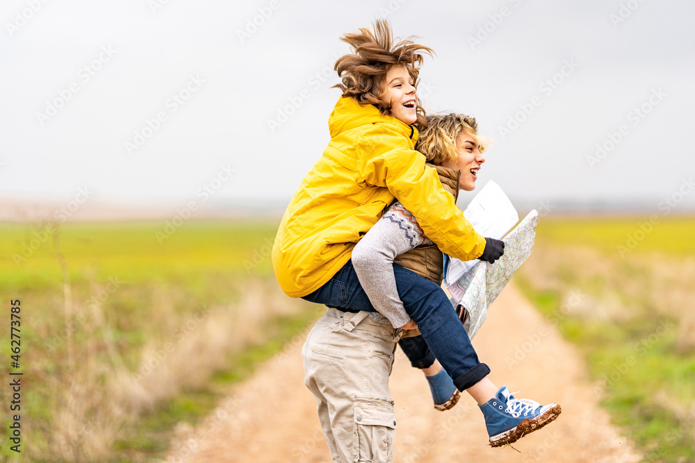 Young man piggybacking younger brother during hike Young man piggybacking younger brother during hike