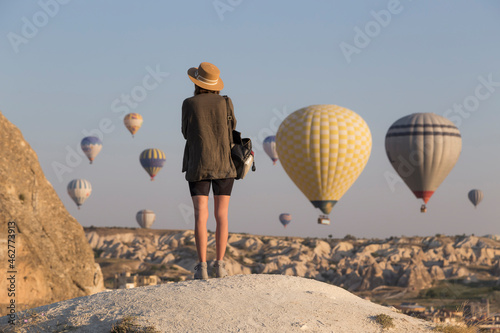 Young woman and hot air ballons, Goreme, Cappadocia, Turkey photo