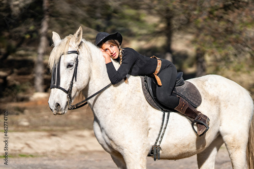 Portrait of woman horseback riding in paddock photo