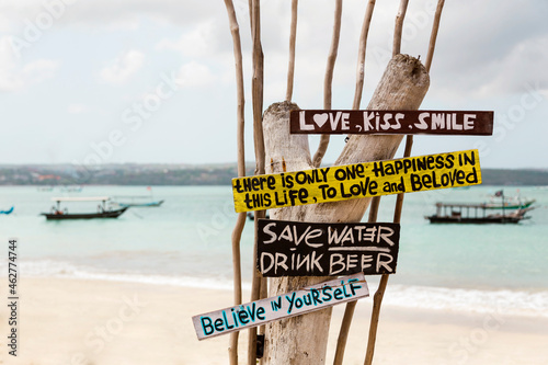 Indonesia, Bali, Jimbaran, Sign with motivational quotes standing on coastal beach photo