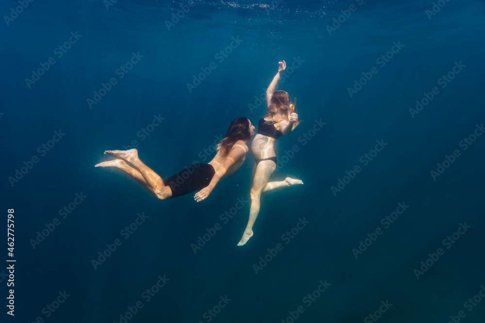 Young couple under water, woman pregnant
