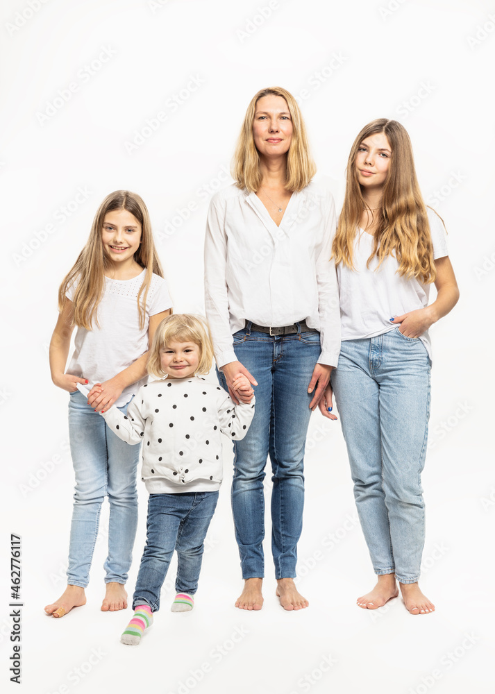 Mother and daughters holding hands while standing in studio Mother and daughters holding hands while standing in studio