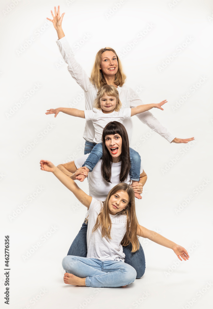 Smiling women with daughters gesturing in studio Smiling women with daughters gesturing in studio