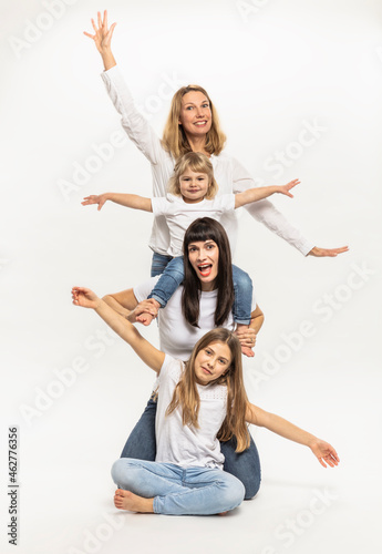 Smiling women with daughters gesturing in studio photo