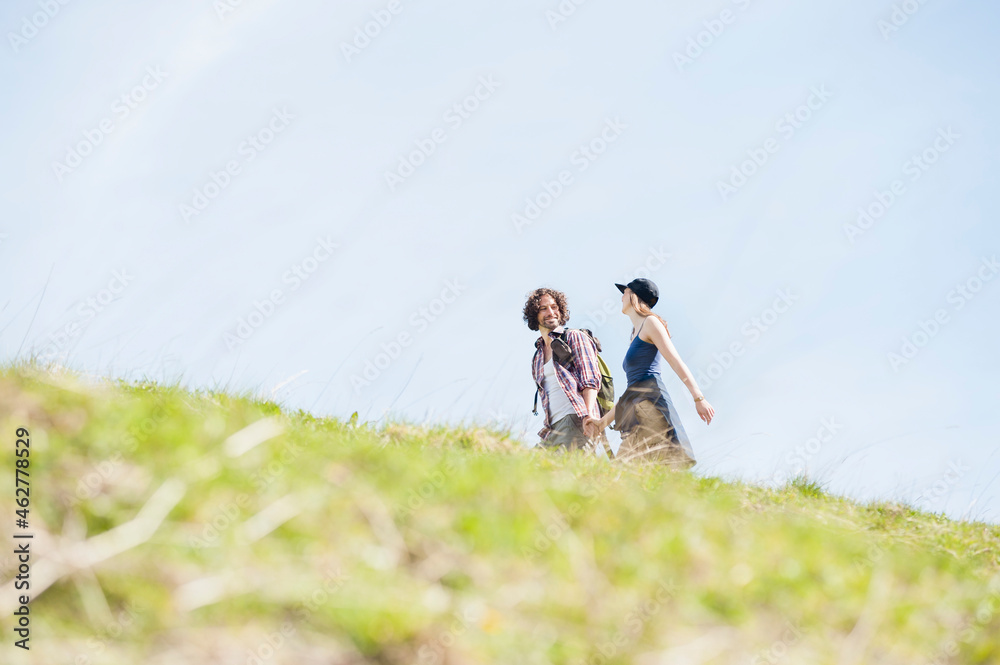 Hiking couple on meadow in summer, Wallberg, Bavaria, Germany Hiking couple on meadow in summer, Wallberg, Bavaria, Germany