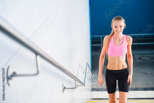 Smiling female jogger on stairs photo