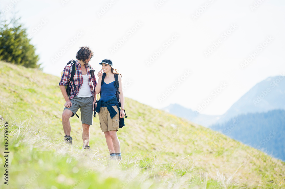 Hiking couple on meadow in summer, Wallberg, Bavaria, Germany Hiking couple on meadow in summer, Wallberg, Bavaria, Germany