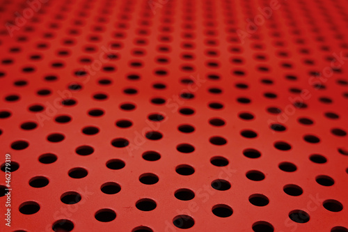 Red perforated metal sheet. Metal plate background or steel texture surface 