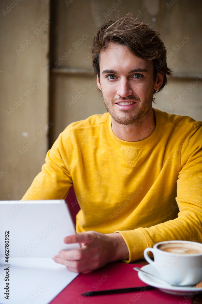 Portrait of young man with digital tablet in a coffee shop