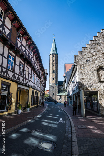 Germany, Lower Saxony, Goslar, Alley in historical town with tower of Market Church Saint Cosmas and Damian in background photo